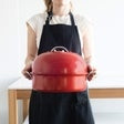 Red kettle smoker carried with domed lid closed