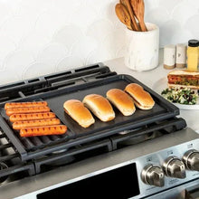 Dual-top grill griddle with grill press, black plate with hot dogs and buns