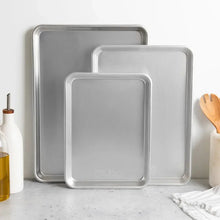 Three-piece baking sheet set with three rectangular metal pans nested together