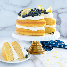 Stacked lemon-blueberry cakes with white cream on a pedestal stand