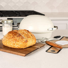 Sourdough baking cloche set with golden loaf on wooden board