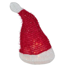 Santa hat tree topper with red fuzzy cone, gray side pom, white brim, warm clear lights