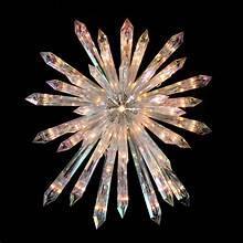 Clear plastic Christmas tree topper starburst with faceted rays and central light
