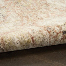 Close-up of beige rug with distressed multicolor speckled pattern and soft pile