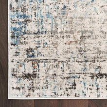 Area rug border detail with distressed ivory field and muted blue linear motifs.