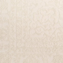 Beige area rug with embossed-like swirling allover texture