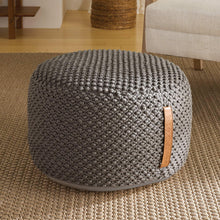 Dark gray woven looped pouf with tan leather patch and rounded top
