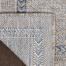Rug corner with woven texture, blue dots, and short frayed edging