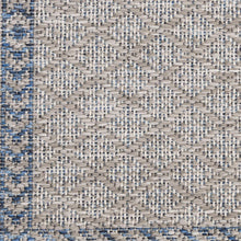 Gray woven rug surface with repeating white and blue speckled pattern
