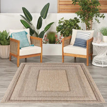 Indoor/outdoor rug with beige and taupe geometric center panel and border