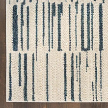 Close-up of cream runner rug with navy-blue vertical stripe motif on textured pile.