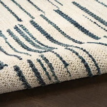 Textured cream rug corner with loop pile and navy-blue stripe lines.