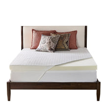 White mattress topper with pale yellow side layer, centered on bed platform
