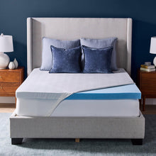 Cooling gel memory foam mattress topper with blue gel layer on bed, draped cover