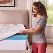 Blue gel memory foam mattress topper section revealed on a white bed