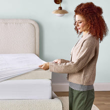 Gel memory foam mattress topper being smoothed on the bed surface