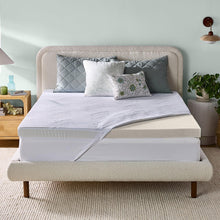 Gel memory foam mattress topper on a bed with white cover and quilted pillows