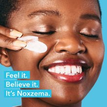 Woman’s face with white cleansing foam on cheek, eyes closed
