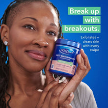 Anti-blemish pads jar held near a woman's face, blue-lidded container
