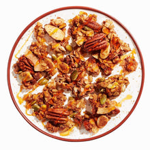 Cinnamon pecan nut granola in bowl with nuts and coconut flakes