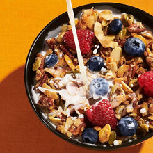 Bowl of cinnamon pecan granola topped with yogurt, blueberries, and raspberries