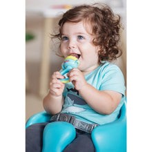 Infant holding a blue and lime soft foods feeder with clear covered silicone tip