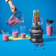 Countertop blender with clear pitcher and two single-serve cups with smoothie