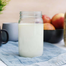 Powdered milk in clear jar with white powder, on blue cloth