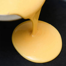 Powdered vitamin egg mixture pouring into pan, creamy yellow