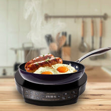 Black induction cooktop running a pan with eggs and meat