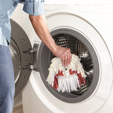 White microfiber spin mop head being placed into a wringer bucket