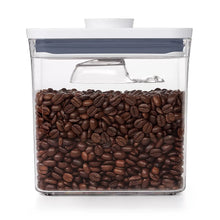 Coffee scoop container filled with roasted coffee beans, clear body and blue lid