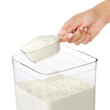 OXO POP container with rice scoop being used to pour grains into a clear bin