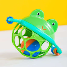 Close-up of green frog jingle rattle with teal bar and multicolor ring grips