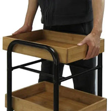 Hand lifting upper tier of 3-tier storage cart, black metal frame and wood shelves