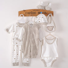 Baby layette set with striped romper, printed pajama set, bib, hat, and socks
