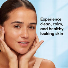Woman with cleanser foam on face, hands resting on cheeks