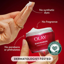 Hand holding a red face cream jar; white cream smear on fingers