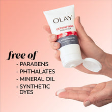Olay Detoxifying Pore Scrub face wash tube with white pump cap, held in hands