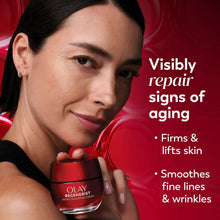 Woman holding OLAY Regenerist Micro-Sculpting Cream jar while applying cream to cheek