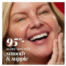 Woman smiling with hand at cheek; facial moisturizer application