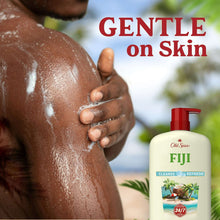 Fiji body wash bottle with red pump beside a hand washing a wet shoulder.