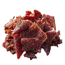 Peppered beef jerky pieces pile with red-brown color and visible seasoning