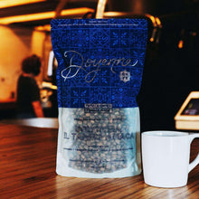 Whole bean coffee bag with blue pattern and Colombia El Tambo-Amacía front label