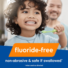 Child brushing with green training toothbrush; fluoride-free non-abrasive toothpaste