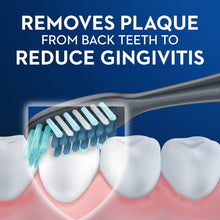 Soft manual toothbrush head with blue bristles cleaning back teeth.