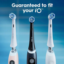 Oral-B iO replacement brush heads positioned on black and white toothbrush handles