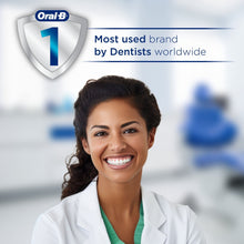 Smiling dentist in lab coat with Oral-B shield branding above