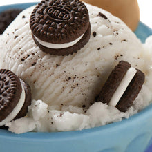 Mini sandwich cookies on white whipped dessert, with chocolate cookie pieces visible