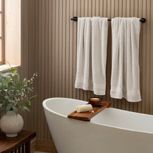 Cream organic cotton bath towel set, two towels hanging on a bar